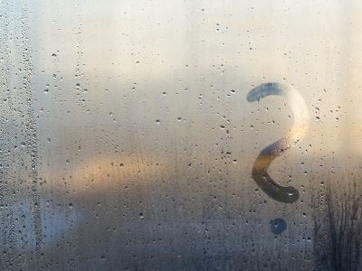 Une fenêtre d'une maison avec beaucoup de condensation et un point d'interrogation dessiné